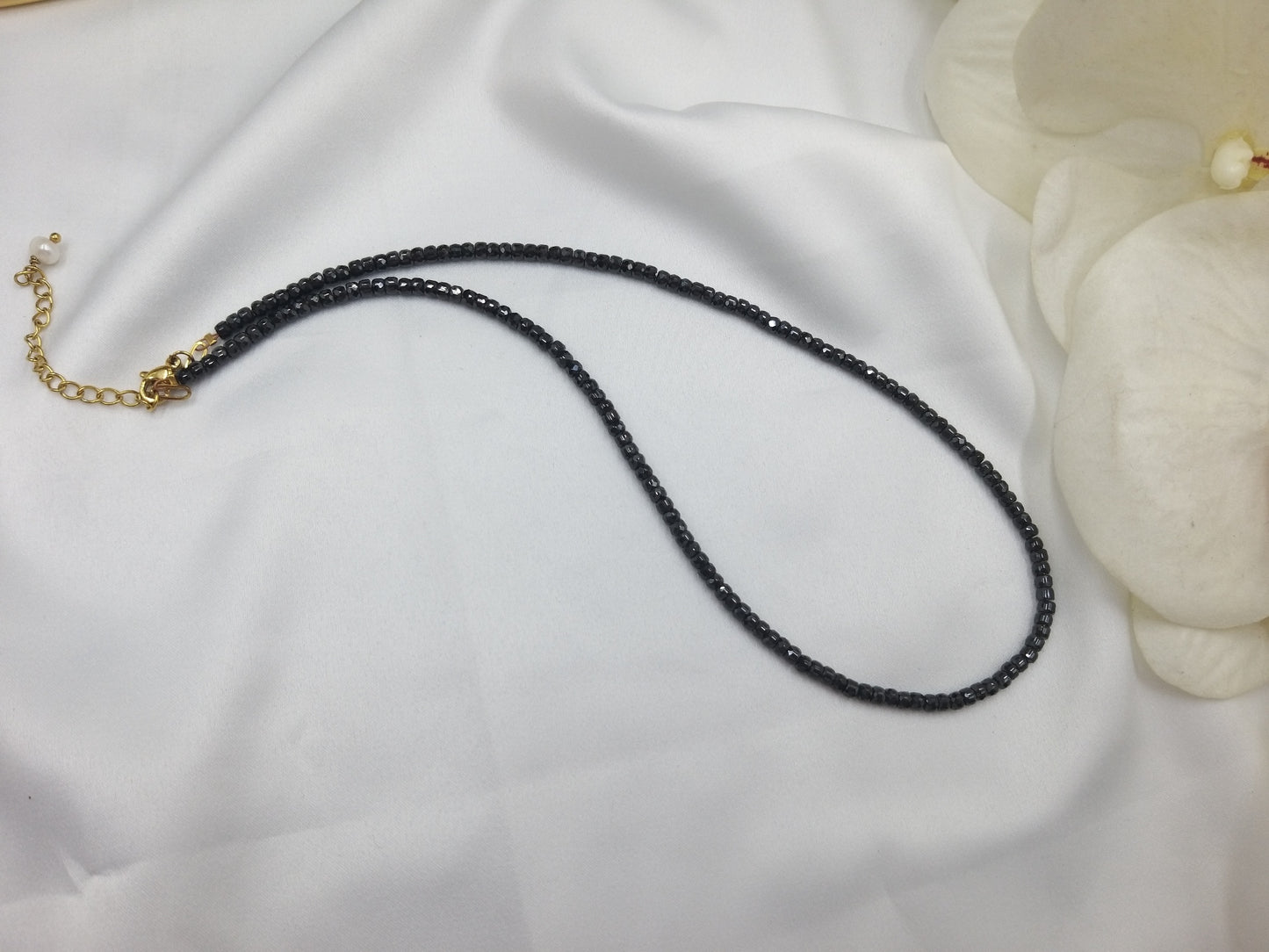 Χειροποίητο κολιέ με ημιπολύτιμες χάντρες ζιργκόν σε βαθύ μπλε, φωτογραφημένο πάνω σε λευκό φόντο.