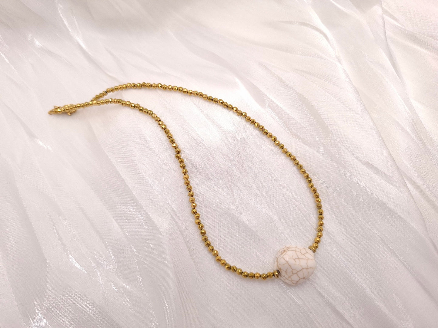 Χειροποίητο κολιέ Desert Pearl από χρυσό αιματίτη και λευκό χαολίτη σε λευκό φόντο από το euhandmade