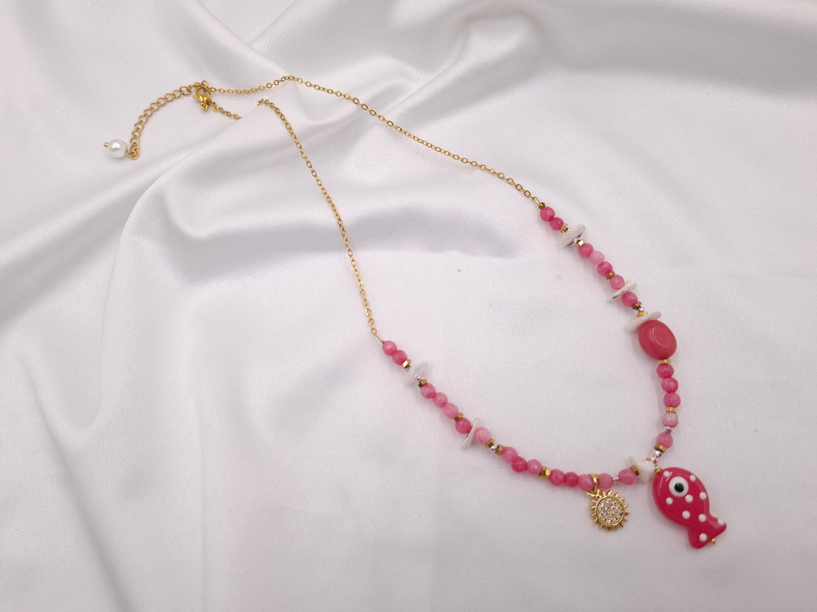 Χειροποίητο κολιέ Fish Tales Pink Lagoon της euhandmade με φούξια χάντρες, γυάλινο ψαράκι, λευκά κοχύλια, στοιχείο ήλιου και χρυσαφί ατσάλινη αλυσίδα.