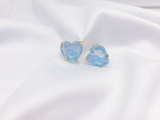 Καρφωτά σκουλαρίκια Drops Heart Studs με γαλάζια κρυστάλλινη καρδιά πάνω σε λευκό σατέν