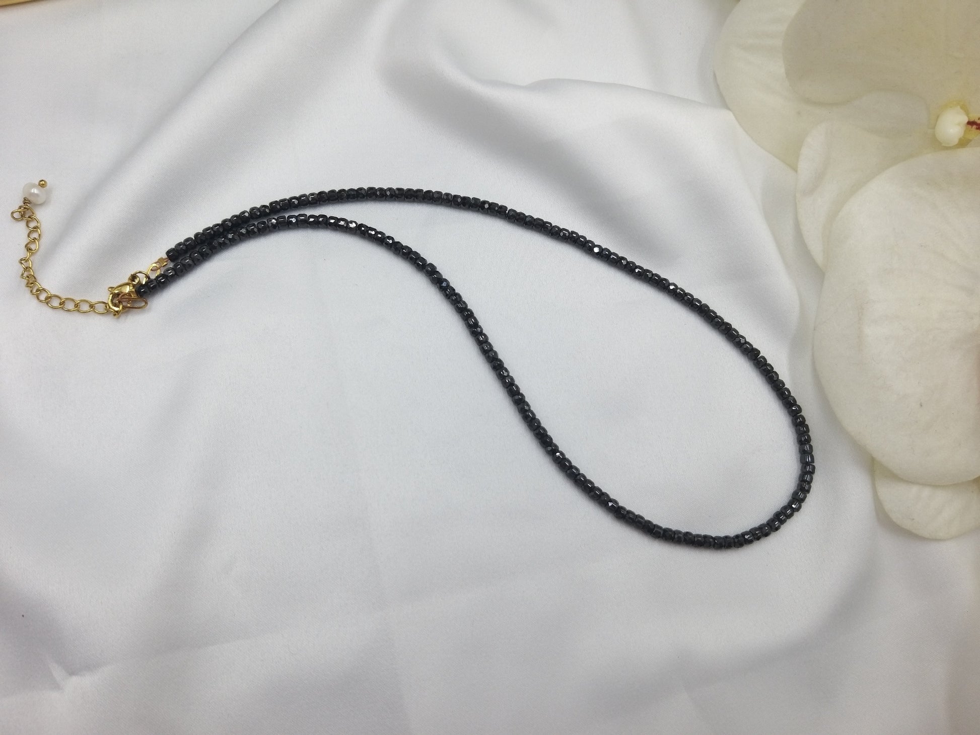 Χειροποίητο κολιέ με ημιπολύτιμες χάντρες ζιργκόν σε βαθύ μπλε, φωτογραφημένο πάνω σε λευκό φόντο.