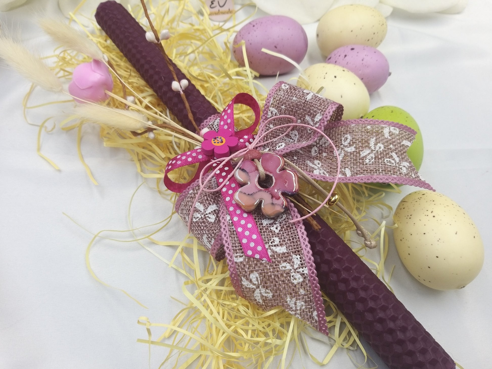 Λεπτομέρεια πασχαλινής λαμπάδας με κεραμικό ροζ λουλούδι, λινάτσα και διακοσμητικό φιόγκο