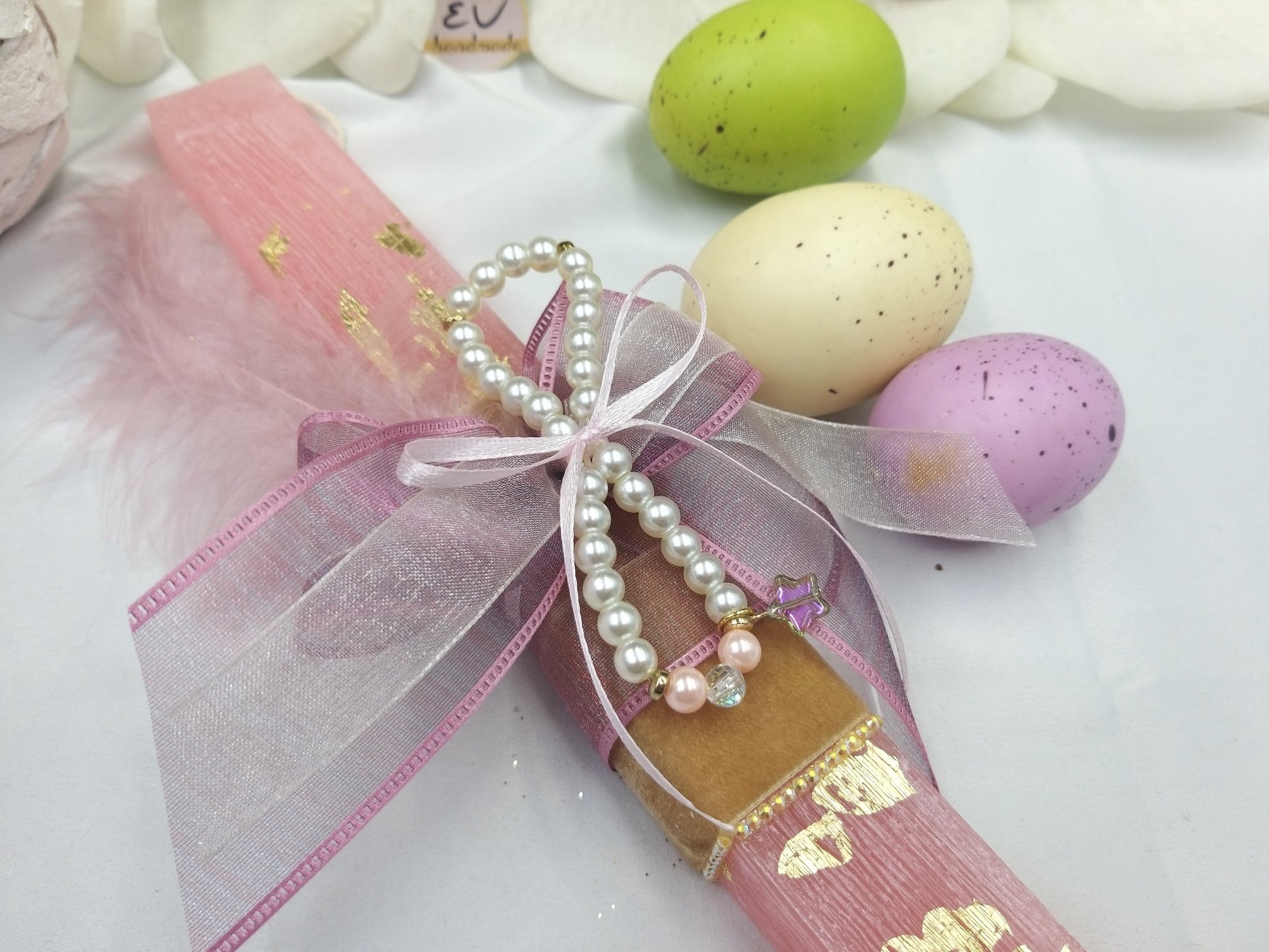 Λεπτομέρεια βραχιολιού με πέρλες σε ροζ πασχαλινή λαμπάδα