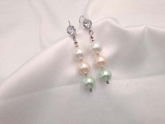 Χειροποίητα σκουλαρίκια Whispering Pearls με τρεις πέρλες σε λευκό, ροζ και μέντα και λαμπερό κρύσταλλο