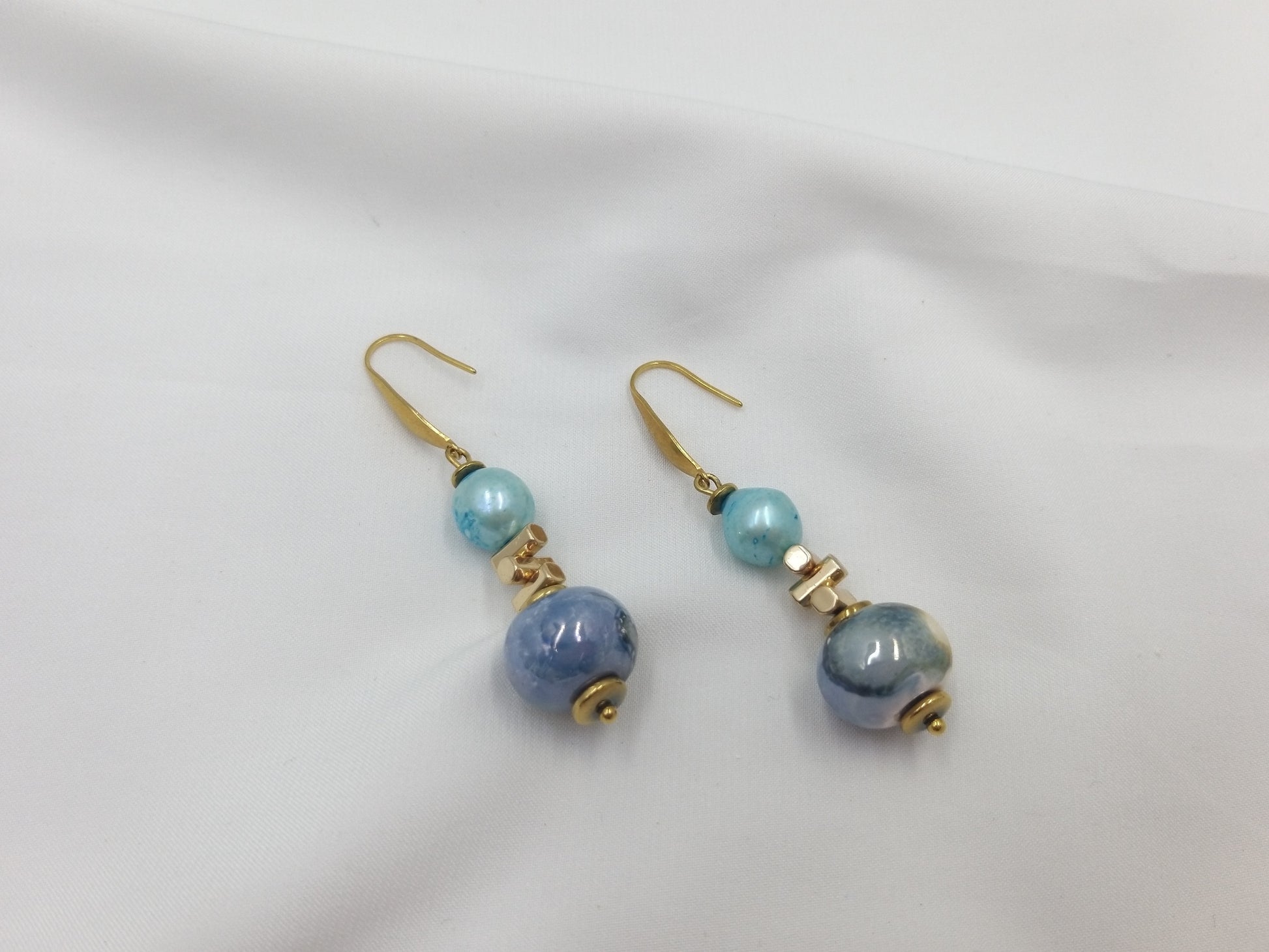 Χειροποίητα σκουλαρίκια με μπλε και τιρκουάζ μαργαριτάρια με χρυσές λεπτομέρειες.