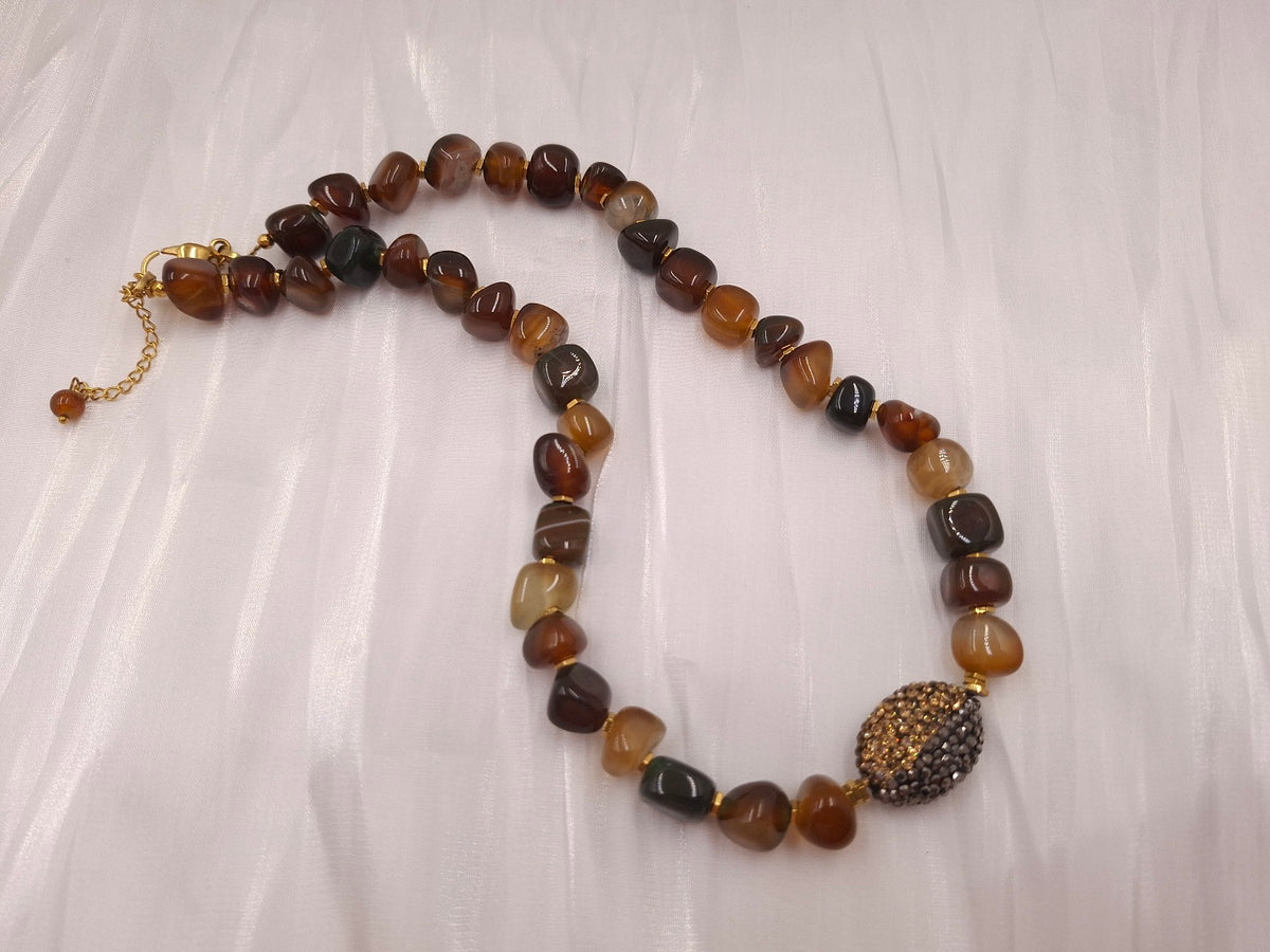 Χειροποίητο κολιέ euhandmade με αχάτη σε μελί και καφέ αποχρώσεις, χρυσόχρωμες λεπτομέρειες και δίχρωμο οβάλ μοτίφ μαρκασίτη.