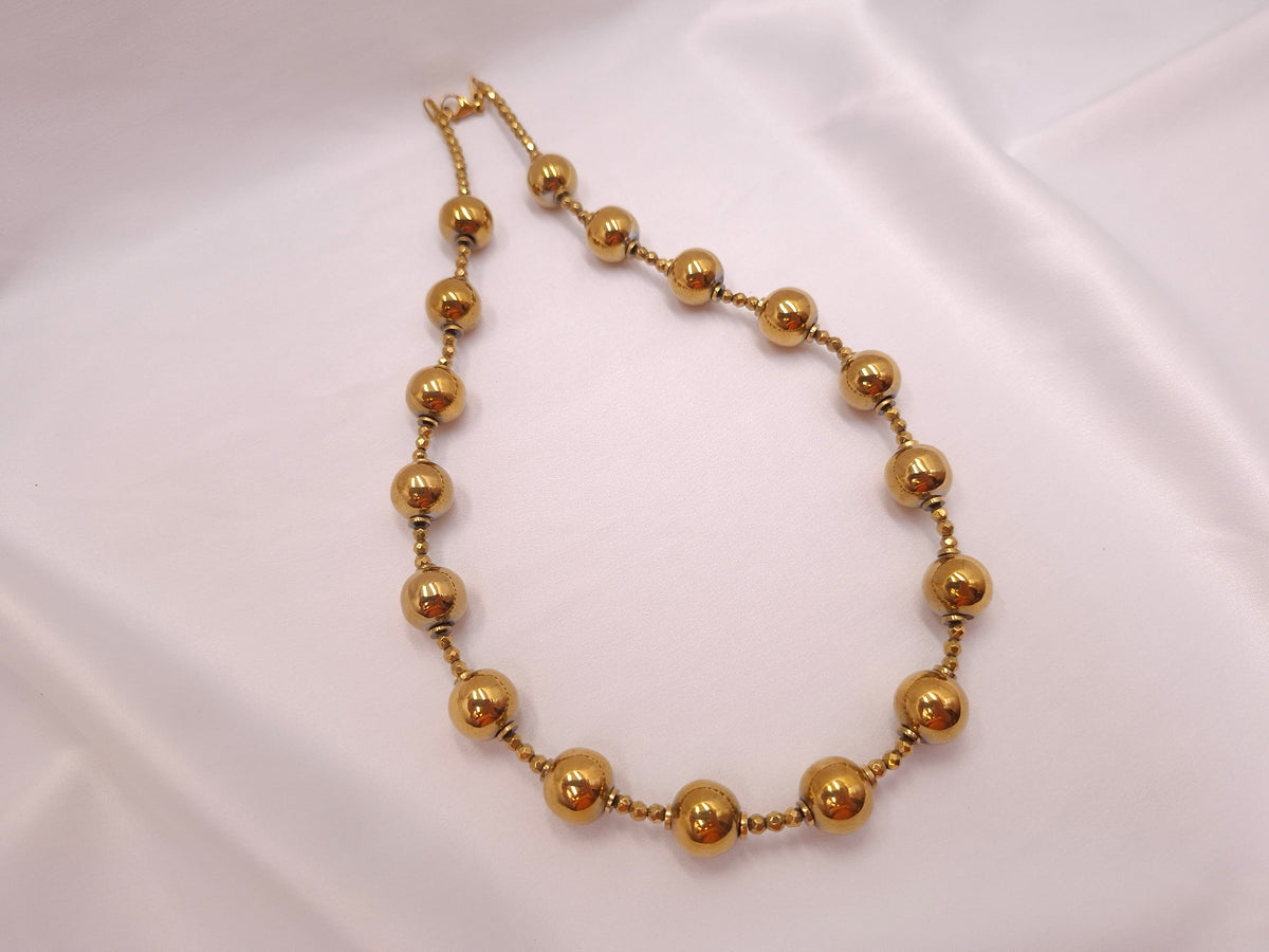 Χειροποίητο κοντό γυναικείο κολιέ euhandmade με χρυσαφί σφαίρες αιματίτη 12mm, μικρές πολύπλευρες χάντρες και αλυσίδα προέκτασης.