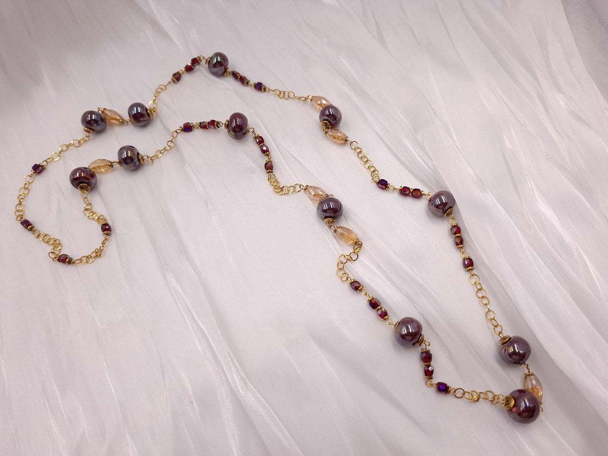 Χειροποίητο μακρύ κολιέ euhandmade με μπορντό ιριδίζουσες κεραμικές χάντρες 13mm, κρύσταλλα σε σαμπανί και μπορντό αποχρώσεις και χρυσαφί ατσάλινη αλυσίδα