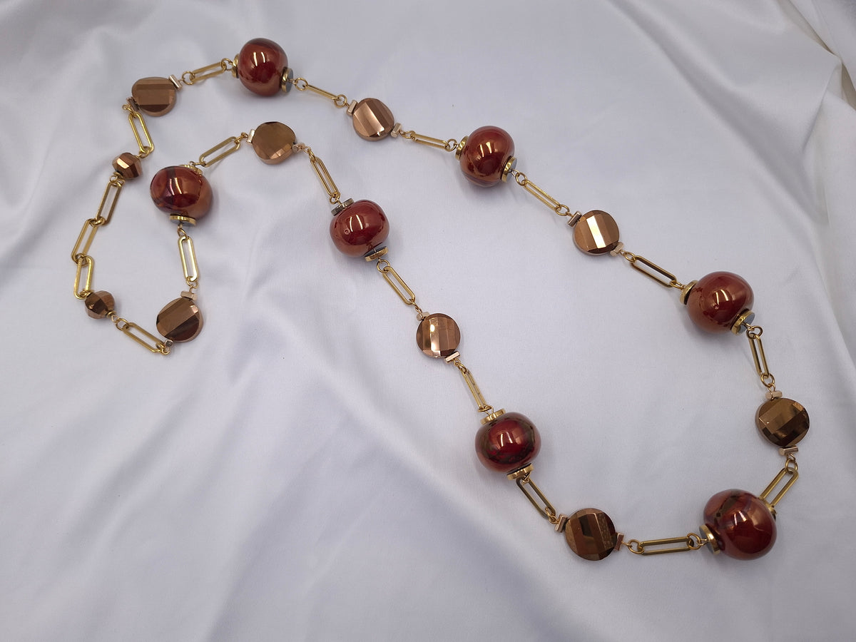 Χειροποίητο μακρύ κολιέ euhandmade με μπορντό κεραμικές χάντρες 22mm, μπρονζέ κρύσταλλα και χρυσαφί ατσάλινη αλυσίδα.