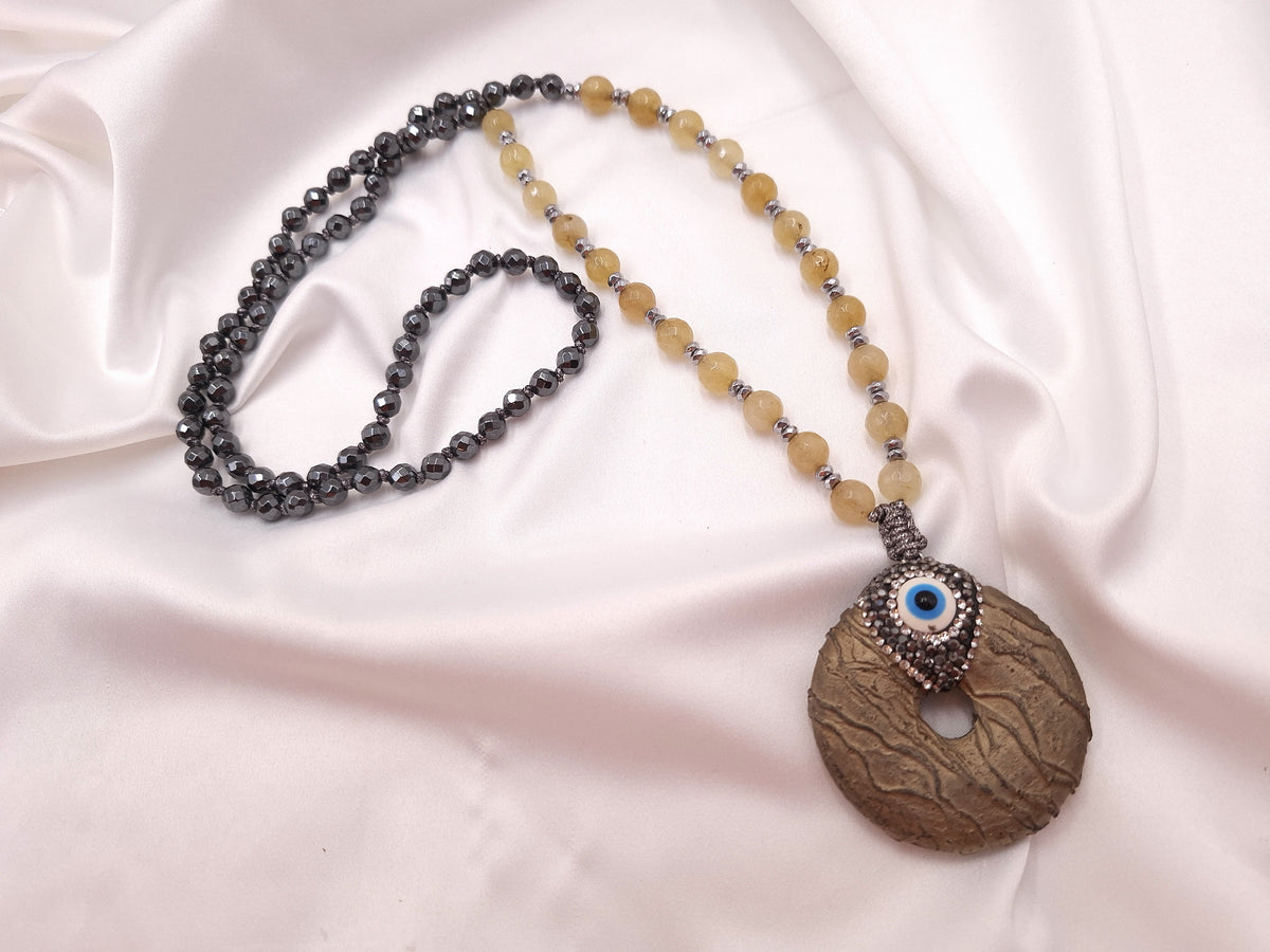 Χειροποίητο μακρύ κολιέ ροζάριο euhandmade με ανάγλυφο κρίκο λάβας, διακοσμητικό μάτι, μπεζ αχάτη και σκούρο φυσικό αιματίτη